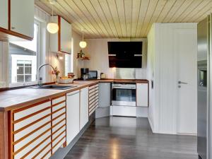 eine Küche mit weißen Schränken und einem Waschbecken in der Unterkunft Holiday Home Edel - 650m from the sea in NE Jutland by Interhome in Hadsund