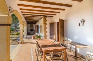 una mesa de madera y sillas en un patio en Club Villamar - Alvent, en Banyeres del Penedés