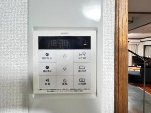 un termostato en una pared en una habitación en Fieldnever Apartment STAY - Maisonette Family room en Fukuoka