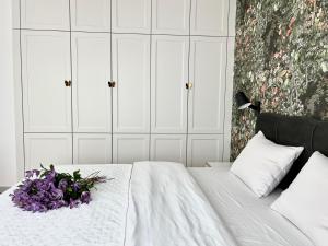 a bedroom with a bed with purple flowers on it at Apartament Hawkinsa in Jelenia Góra +14 photos