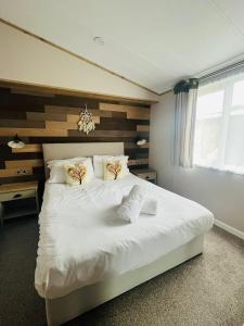 1 dormitorio con 1 cama blanca y 2 toallas en Lucky Lodge with Hot Tub, en York