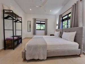 a bedroom with a large bed and two windows at Villa Laure in Grand'Anse Praslin