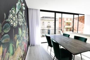 科英布拉的住宿－Brasil Residences，一间带桌子和绿色椅子的用餐室