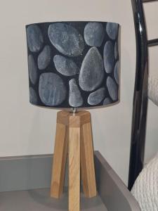 a lamp sitting on a table with rocks on it at The Den - A modern, quirky room, new for 2023. in Braunton