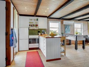 kuchnia z białymi urządzeniami i stołem w pokoju w obiekcie Holiday Home Stella - 700m from the sea in NW Jutland by Interhome w mieście Hjørring