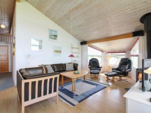 een woonkamer met een bank en een tafel bij Holiday Home Fanni - 300m from the sea in NW Jutland by Interhome in Hjørring