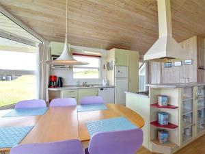 een keuken en eetkamer met een tafel en paarse stoelen bij Holiday Home Fanni - 300m from the sea in NW Jutland by Interhome in Hjørring