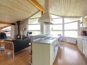 een keuken en een woonkamer met een kookplaat. bij Holiday Home Fanni - 300m from the sea in NW Jutland by Interhome in Hjørring