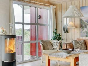 een woonkamer met een open haard en een tafel bij Holiday Home Iacobus - 400m from the sea in NW Jutland by Interhome in Hjørring