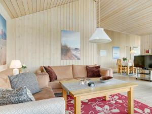 een woonkamer met een bank en een tafel bij Holiday Home Iacobus - 400m from the sea in NW Jutland by Interhome in Hjørring