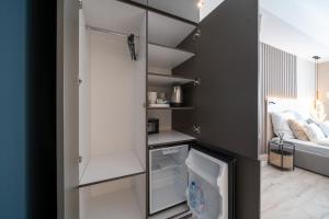 a small kitchen with a white refrigerator in a room at Karoly Boutique Suites, Best Location by BQA in Budapest