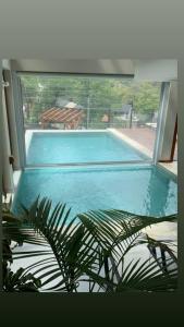 a view of a swimming pool through a large window at Origen de la Bahia in Villa La Angostura