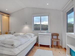 - une chambre blanche avec un grand lit et une fenêtre dans l'établissement Holiday Home Danja - 400m from the sea in NW Jutland by Interhome, à Hjørring
