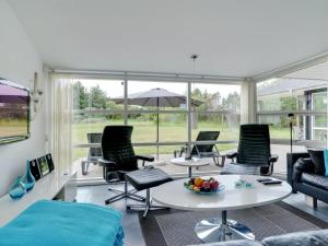 sala de estar con sillas, mesa y sombrilla en Holiday Home Aiyana - 530m from the sea in NW Jutland by Interhome, en Hjørring