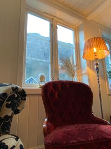 Zimmer mit einem Stuhl, einer Lampe und einem Fenster in der Unterkunft Sentralt hus i Rjukan in Rjukan