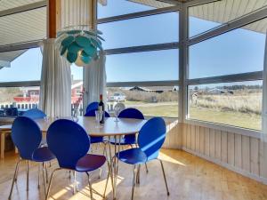 - une salle à manger avec une table, des chaises et de grandes fenêtres dans l'établissement Holiday Home Zafirka - 300m from the sea in NW Jutland by Interhome, à Hjørring