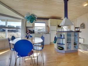 - une cuisine et une salle à manger avec une table et des chaises dans l'établissement Holiday Home Zafirka - 300m from the sea in NW Jutland by Interhome, à Hjørring