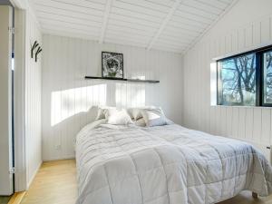 una camera bianca con un grande letto e una finestra di Holiday Home Remko - 1-5km from the sea in NW Jutland by Interhome a Hjørring