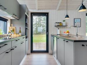 una cucina con armadi bianchi e una porta scorrevole in vetro di Holiday Home Talitha - 1-5km from the sea in NW Jutland by Interhome a Hjørring