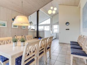 a dining room with a white table and chairs at Holiday Home Thorir - 300m from the sea in NW Jutland by Interhome in Hirtshals