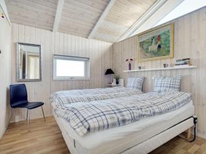 um quarto com uma cama e uma cadeira em Holiday Home Konsta - all inclusive - 200m from the sea by Interhome em Hjørring