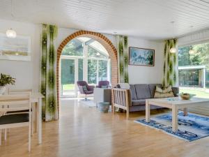 een woonkamer met een bank en een tafel bij Holiday Home Marsa - 1-5km from the sea in NW Jutland by Interhome in Hjørring