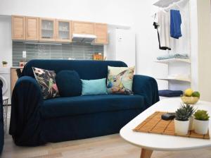 a blue couch in a living room with a table at Pirgos Colorful Studio Sleeps 2 Parking WiFi Ac in Rotásion