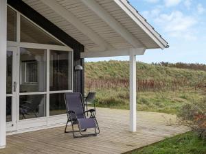 Holiday Home Frejdis - 1-1km from the sea in NW Jutland by Interhome في هيرتسهلس: كرسيان يجلسون على شرفة المنزل