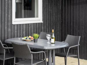 un tavolo con una bottiglia di vino e un cesto di frutta di Holiday Home Frejdis - 1-1km from the sea in NW Jutland by Interhome a Hirtshals