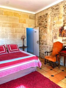 - une chambre avec un lit, une chaise et un bureau dans l'établissement Château Richelieu, à Fronsac