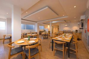 a dining room with wooden tables and chairs at The Grand Tashree at Delhi Airport in New Delhi