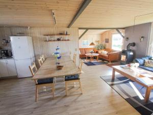 uma cozinha e sala de estar com uma mesa e um frigorífico em Holiday Home Vili - all inclusive - 500m from the sea by Interhome em Hirtshals