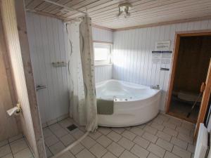 uma banheira na casa de banho com um chuveiro em Holiday Home Vili - all inclusive - 500m from the sea by Interhome em Hirtshals