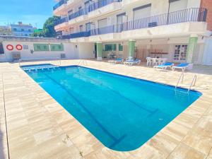 una gran piscina frente a un edificio en LETS HOLIDAYS Quiet apartment with pool in tossa en Tossa de Mar