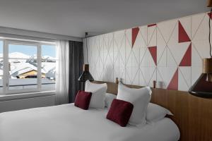 a bedroom with a large bed with red and white pillows at White 1921 Courchevel in Courchevel