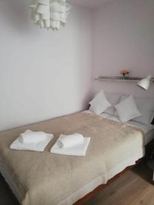 a bedroom with a bed with white towels on it at Apartamencik Perełka in Skoczów