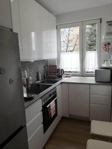 a kitchen with white cabinets and a stove top oven at Apartamencik Perełka in Skoczów
