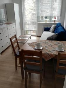 a living room with a table and chairs and a couch at Apartamencik Perełka in Skoczów