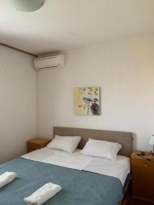 a bedroom with two beds and a painting on the wall at Dubrovnik Rooms 2 in Dubrovnik