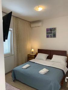 a bedroom with a bed with two towels on it at Dubrovnik Rooms 2 in Dubrovnik