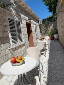 una mesa y sillas con fruta en el patio en Dubrovnik Rooms 2, en Dubrovnik