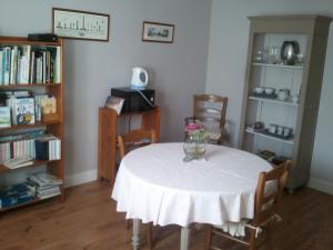 a room with a table with a vase of flowers on it at Les Blancarts in Hautebut