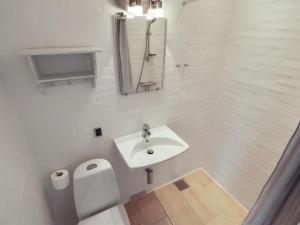 a white bathroom with a sink and a mirror at Apartment Alkmund - 800m from the sea in NW Jutland by Interhome in Skagen