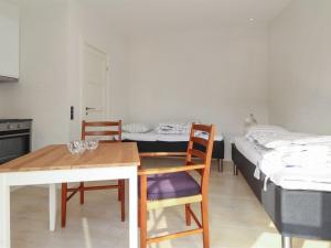 a room with two beds and a table and chairs at Apartment Alkmund - 800m from the sea in NW Jutland by Interhome in Skagen