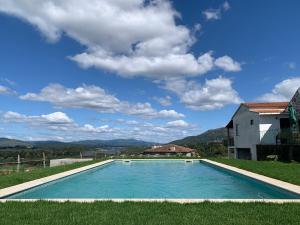 a swimming pool in the middle of a yard with a house at Casas da Loureira - Casa do Agostinho in Gondarém