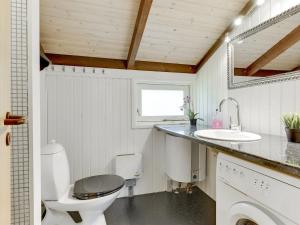 a small bathroom with a toilet and a sink at Holiday Home Eliana - 350m from the sea in NE Jutland by Interhome in Strandby