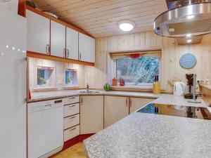 cocina con armarios blancos y encimera en Holiday Home Eljena - 600m from the sea in NE Jutland by Interhome, en Strandby