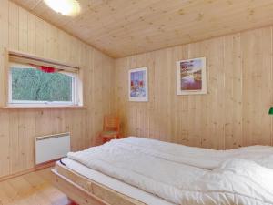 1 dormitorio con 1 cama en una habitación de madera en Holiday Home Eljena - 600m from the sea in NE Jutland by Interhome, en Strandby