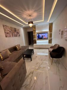 a living room with a couch and a tv at 1 apartment de luxe hay almatar in Nador