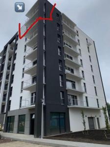 ein großes Apartmenthaus mit einem roten Pfeil darauf in der Unterkunft Apartament Corner Śrem in Śrem
